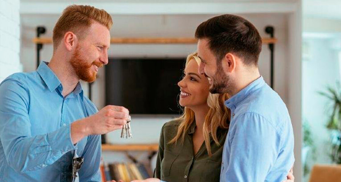 corretor de imóveis entrega chave à casal enquanto todos sorriem após discussão sobre a diferença entre casa e apartamento