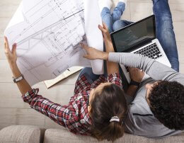 casal observando a planta de um empreendimento enquanto pesquisa as vantagens de comprar um imóvel na planta