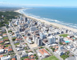 a imagem mostra uma cidade ao lado da praia simbolizando as dicas para comprar um apartamento na praia