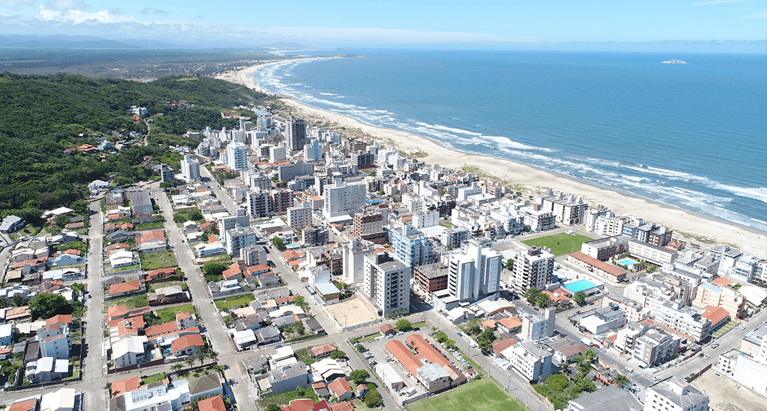 a imagem mostra uma cidade ao lado da praia simbolizando as dicas para comprar um apartamento na praia