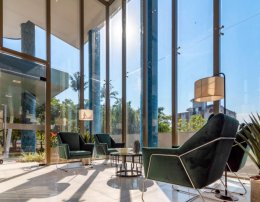 hall apartamento com poltronas verdes, vidraça ampla da Construtora Fontana